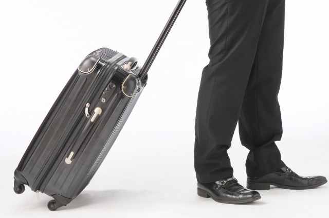 スーツケースをひくビジネスマン